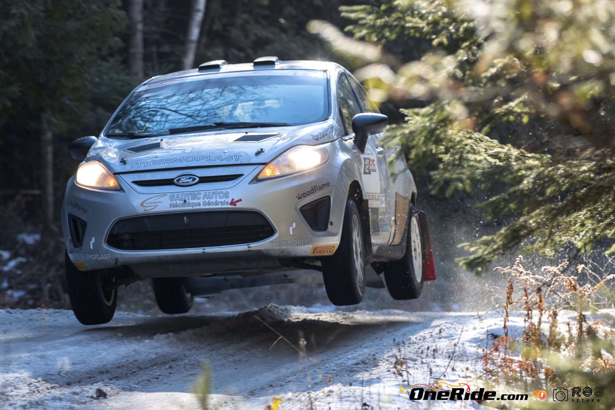 The Ford Fiesta in mid-air over a snowy road, lights on